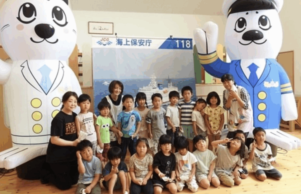 海上保安庁のキャラクターの形をしたエアーサインと写真を撮るたくさんの子どもたちの写真